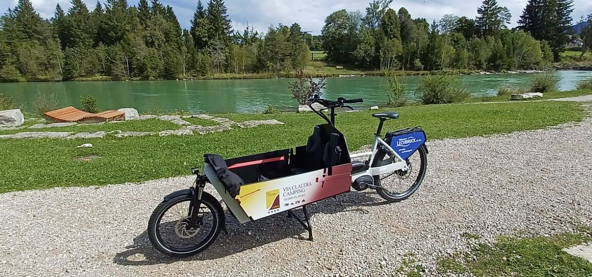 Lastenrad am Weg. Fluss im Hintergrund