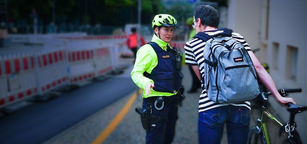 Polizistin spricht mit Radfahrer