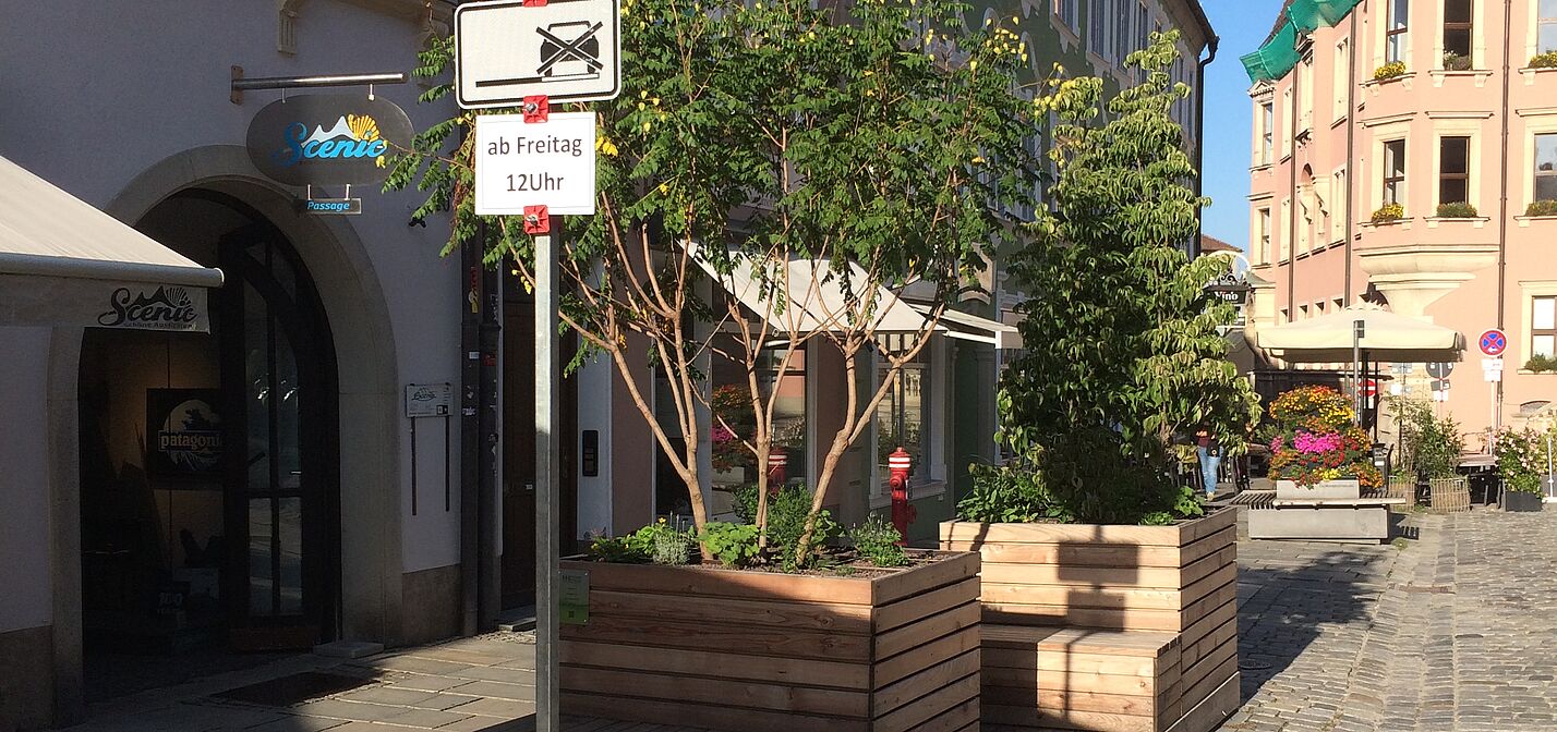 Sitzkisten aus Holz mit Pflanzen in der Innenstadt