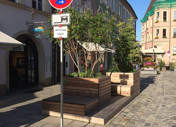 Sitzkisten aus Holz mit Pflanzen in der Innenstadt