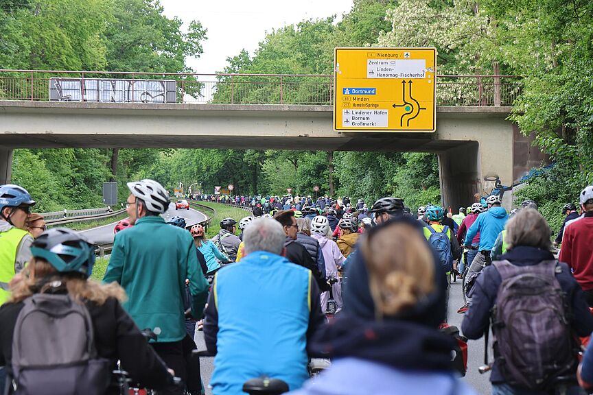 ADFC-Sternfahrt Region Hannover Eine große Gruppe von Radfahrenden fährt auf einer sonst dem Autoverkehr vorbehaltenen Straße.
